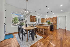 Dining area with plenty of natural light, dark wood finished floors, and a chandelier