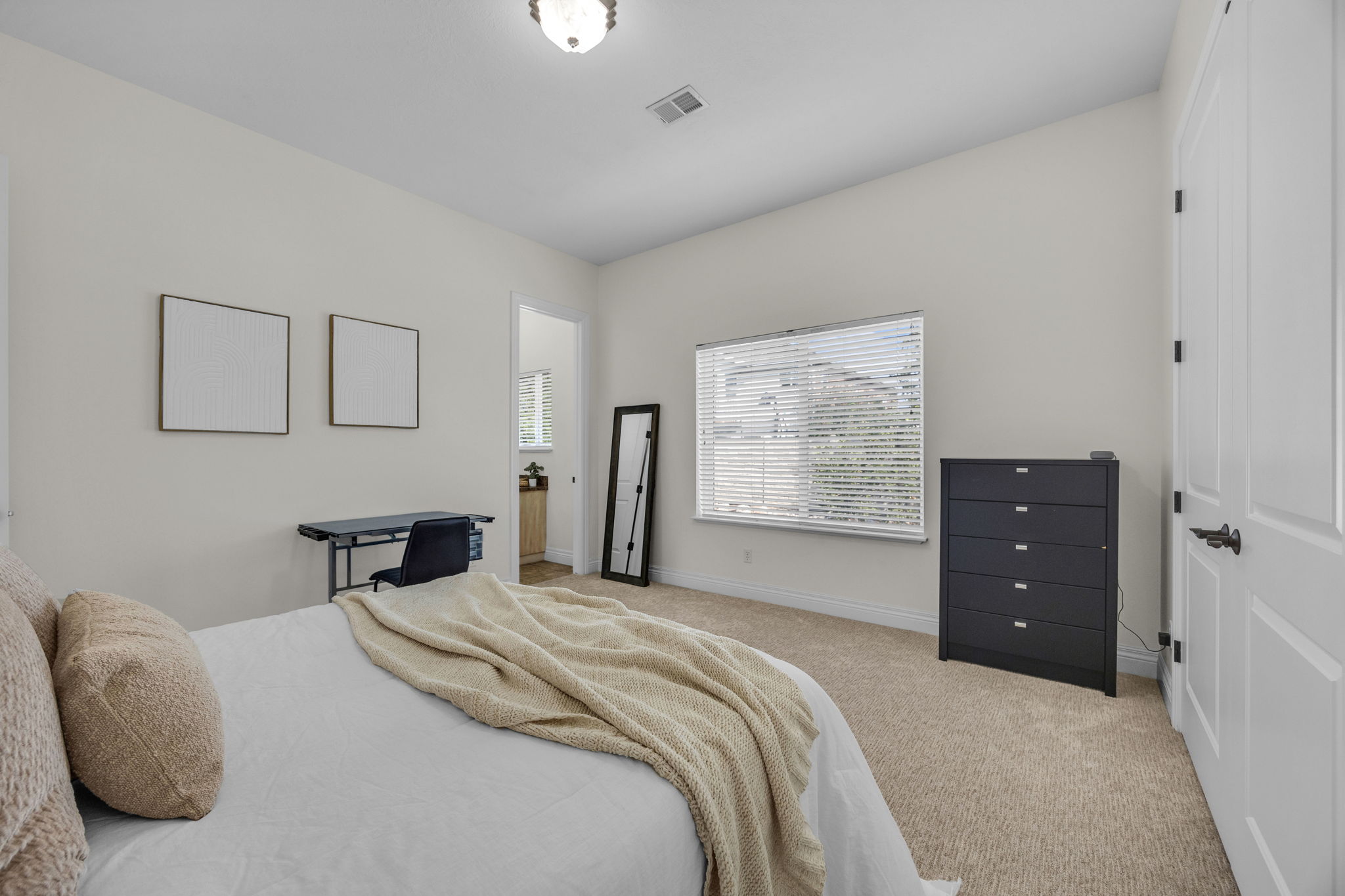 Bedroom with light colored carpet and baseboards