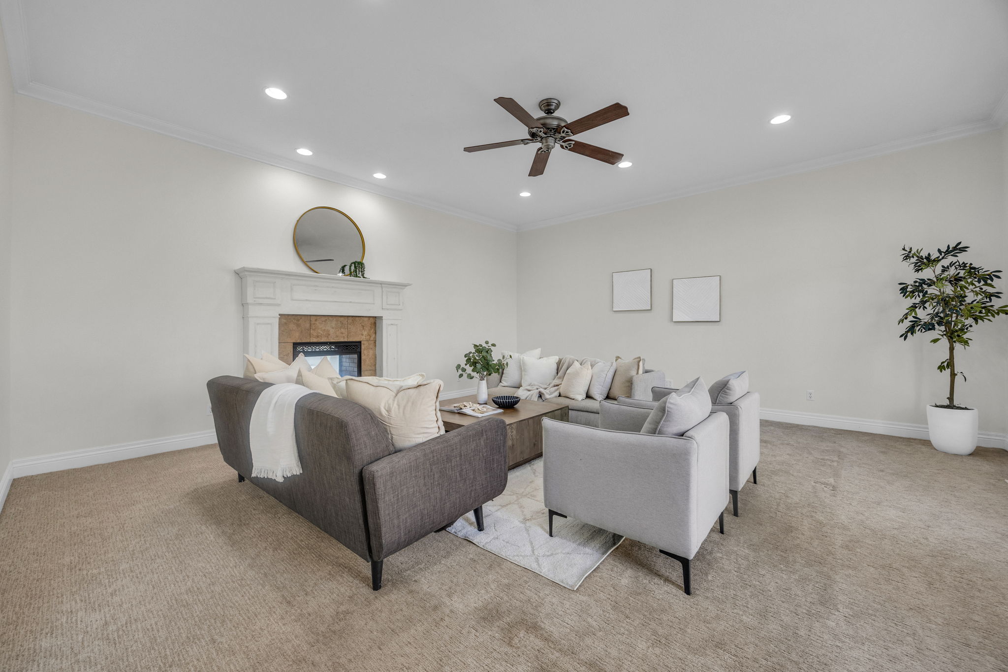 Living area featuring light carpet, crown molding, a ceiling fan, recessed lighting, and a tile fireplace
