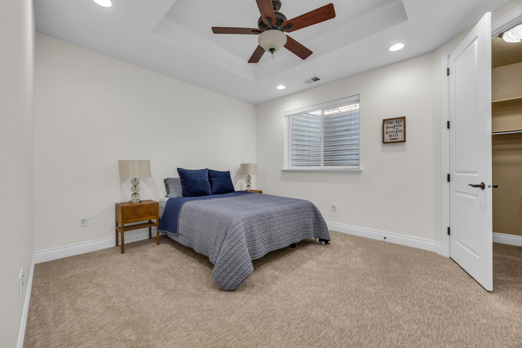 Bedroom featuring recessed lighting, light colored carpet, ceiling fan, and a raised ceiling