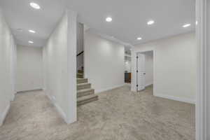 Finished below grade area featuring recessed lighting and light carpet