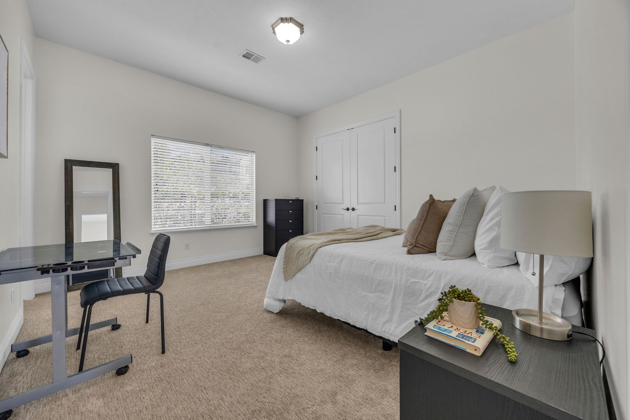 Bedroom with light colored carpet and a closet