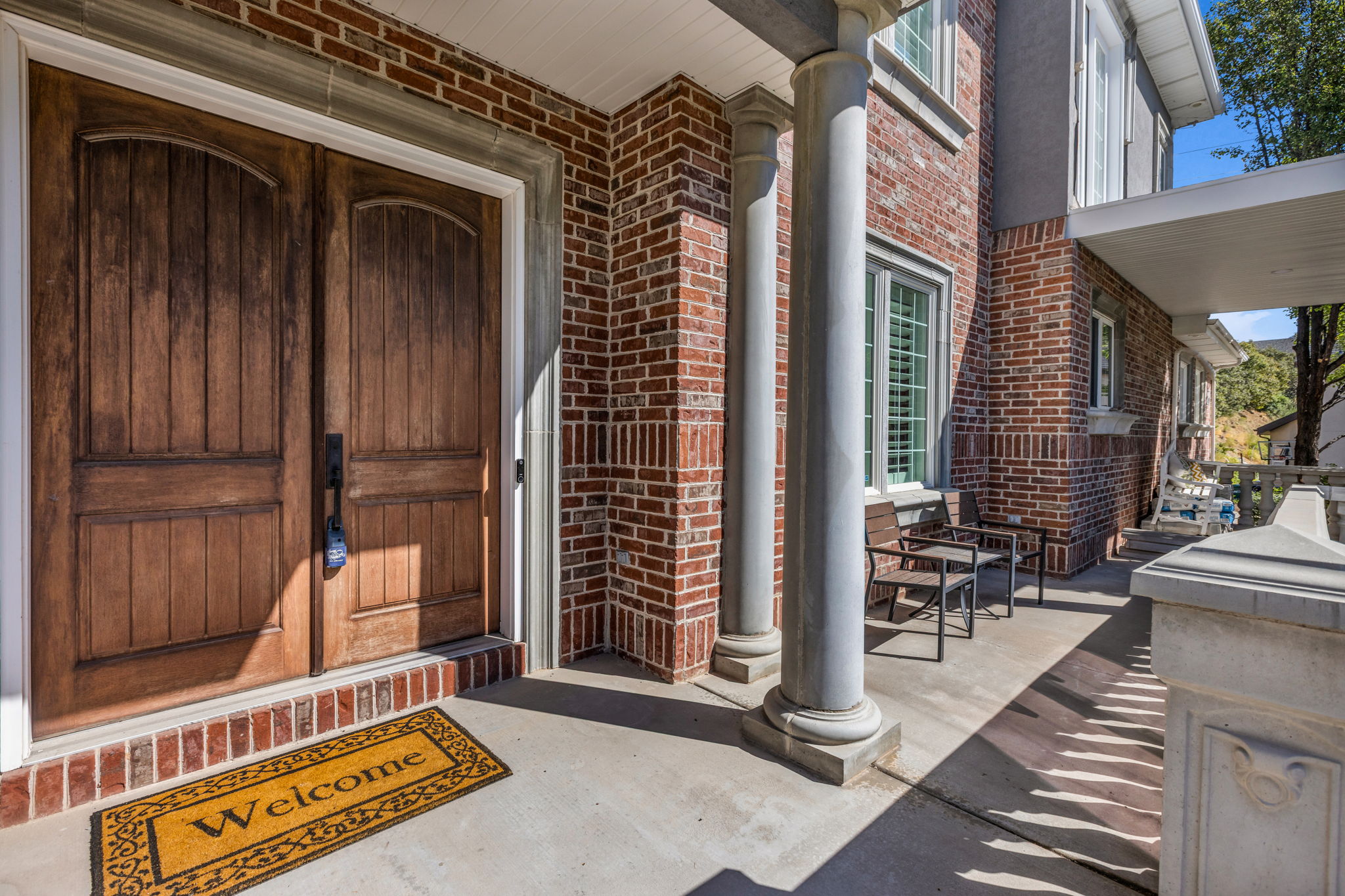 Entrance to property with brick siding and covered porch