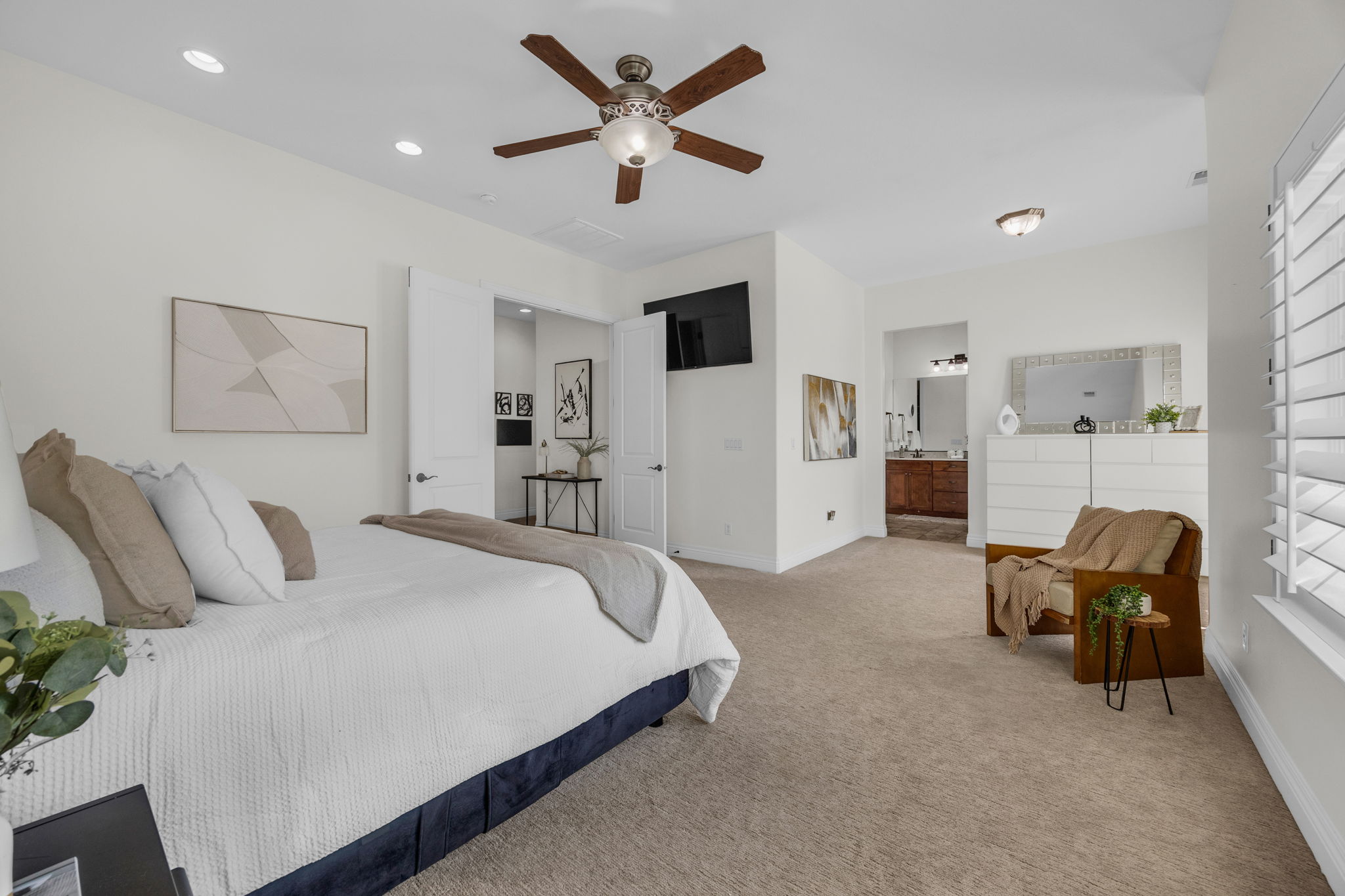 Bedroom with light colored carpet, a ceiling fan, connected bathroom, and recessed lighting