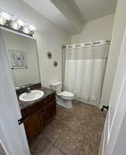 Full bathroom featuring vanity, light tile patterned floors, and shower / bath combo with shower curtain