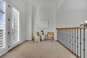 Sitting room featuring carpet, crown molding, and suspended lighting