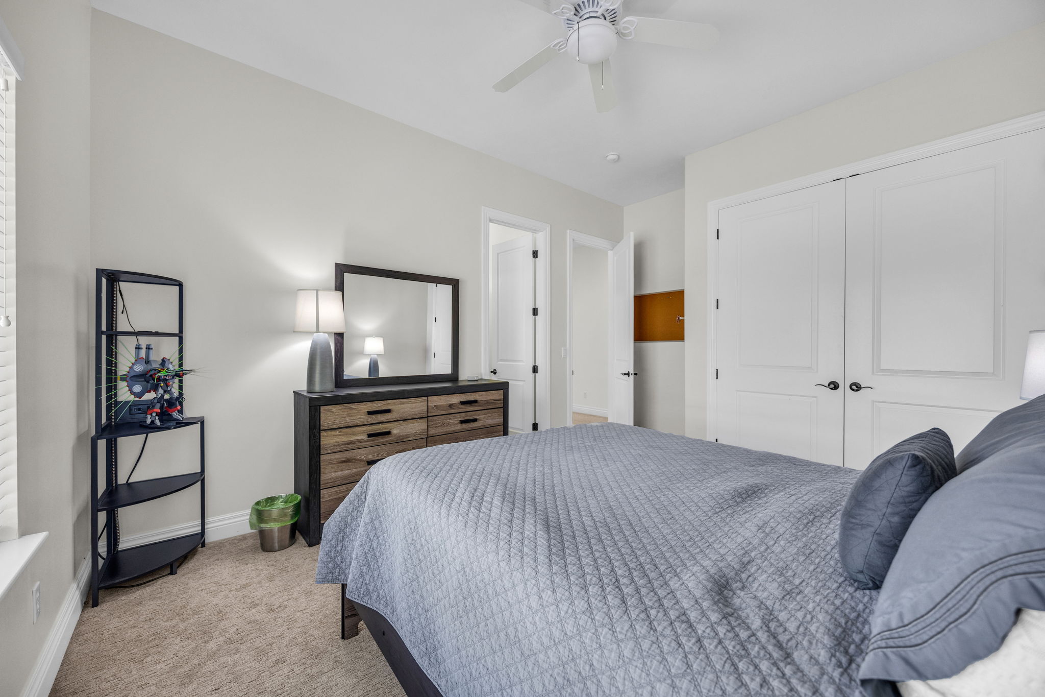 Bedroom featuring light colored carpet, a ceiling fan, and a closet
