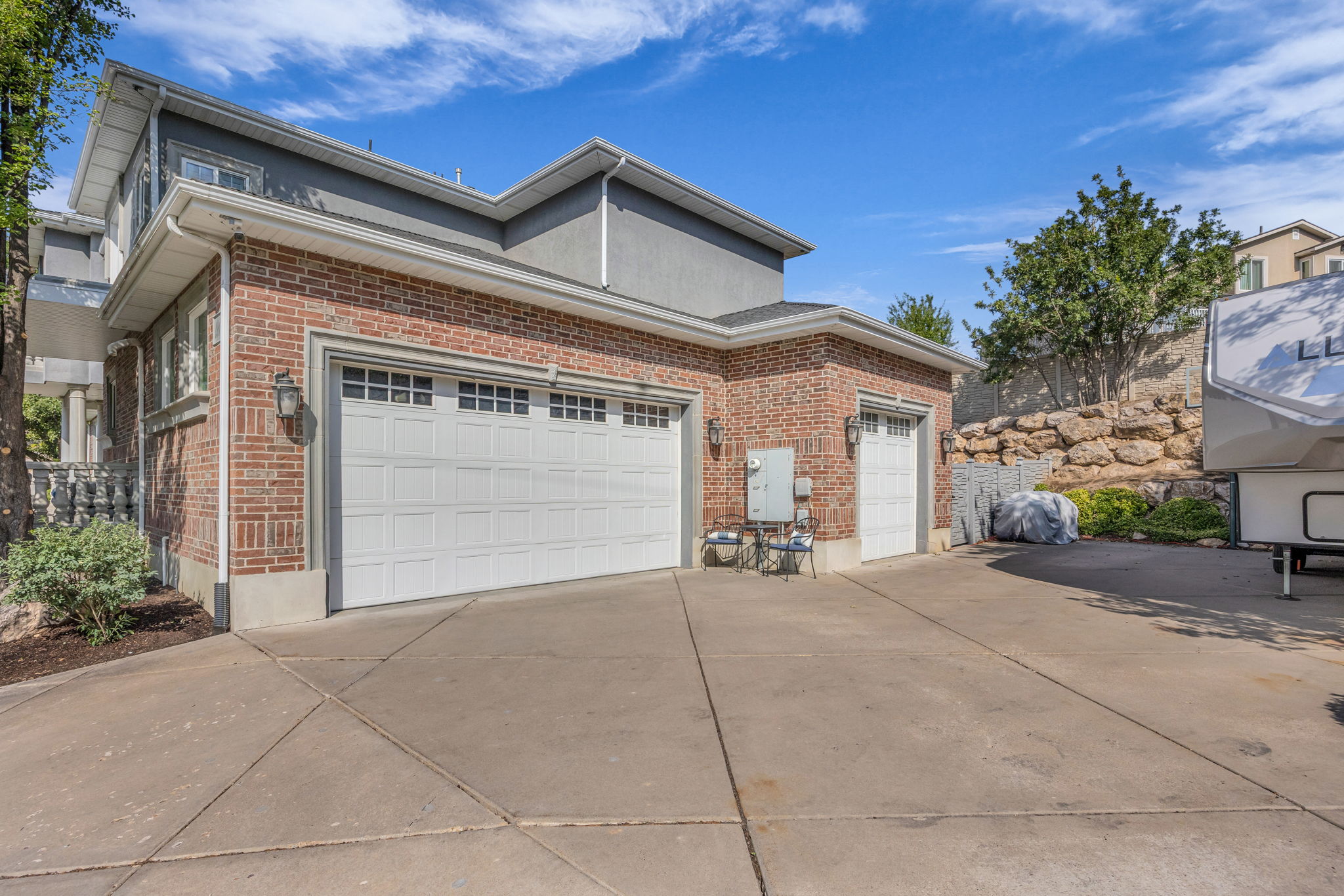 View of side of property featuring brick siding, driveway, and an attached garage