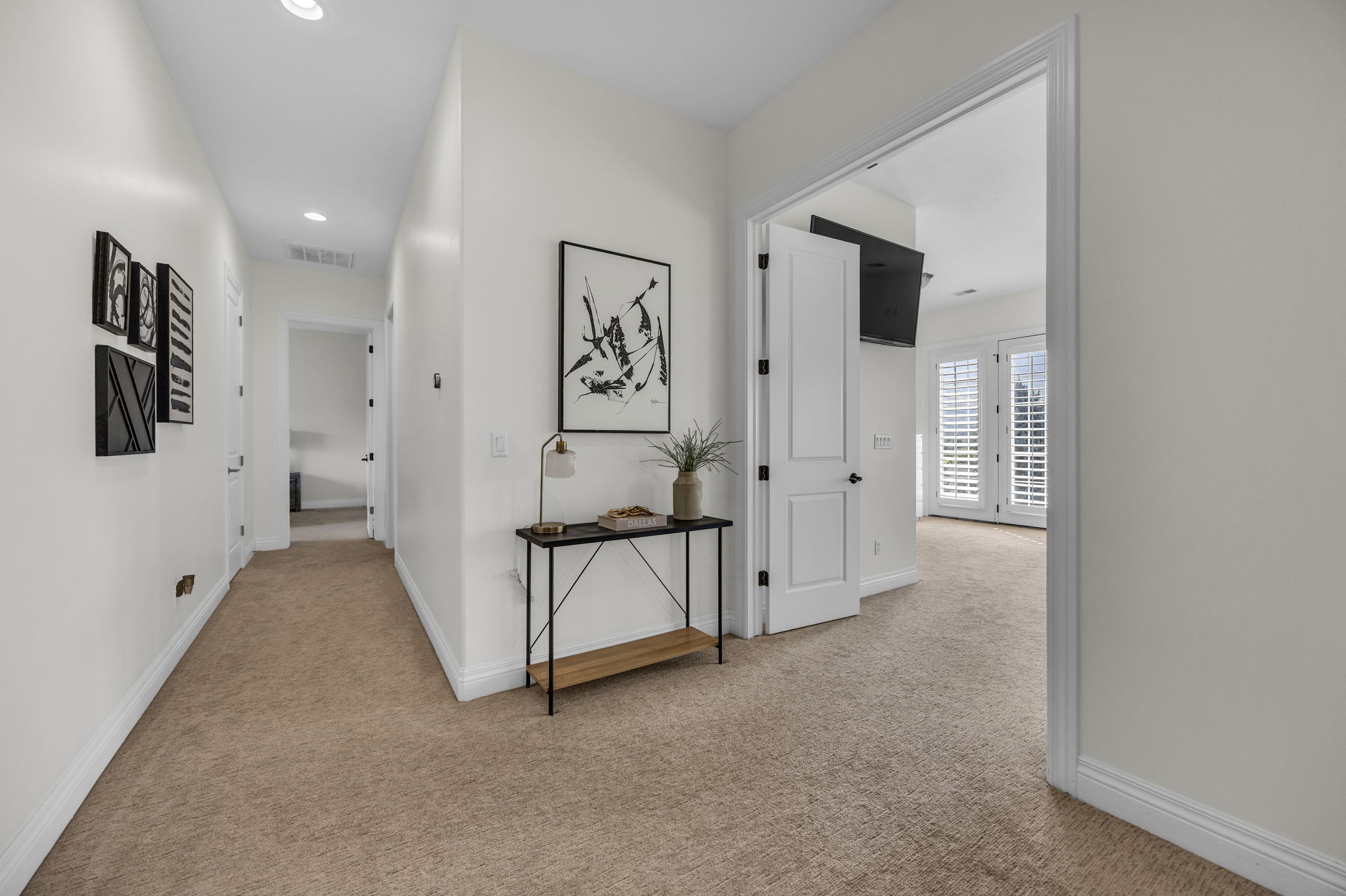 Hall with light colored carpet and recessed lighting