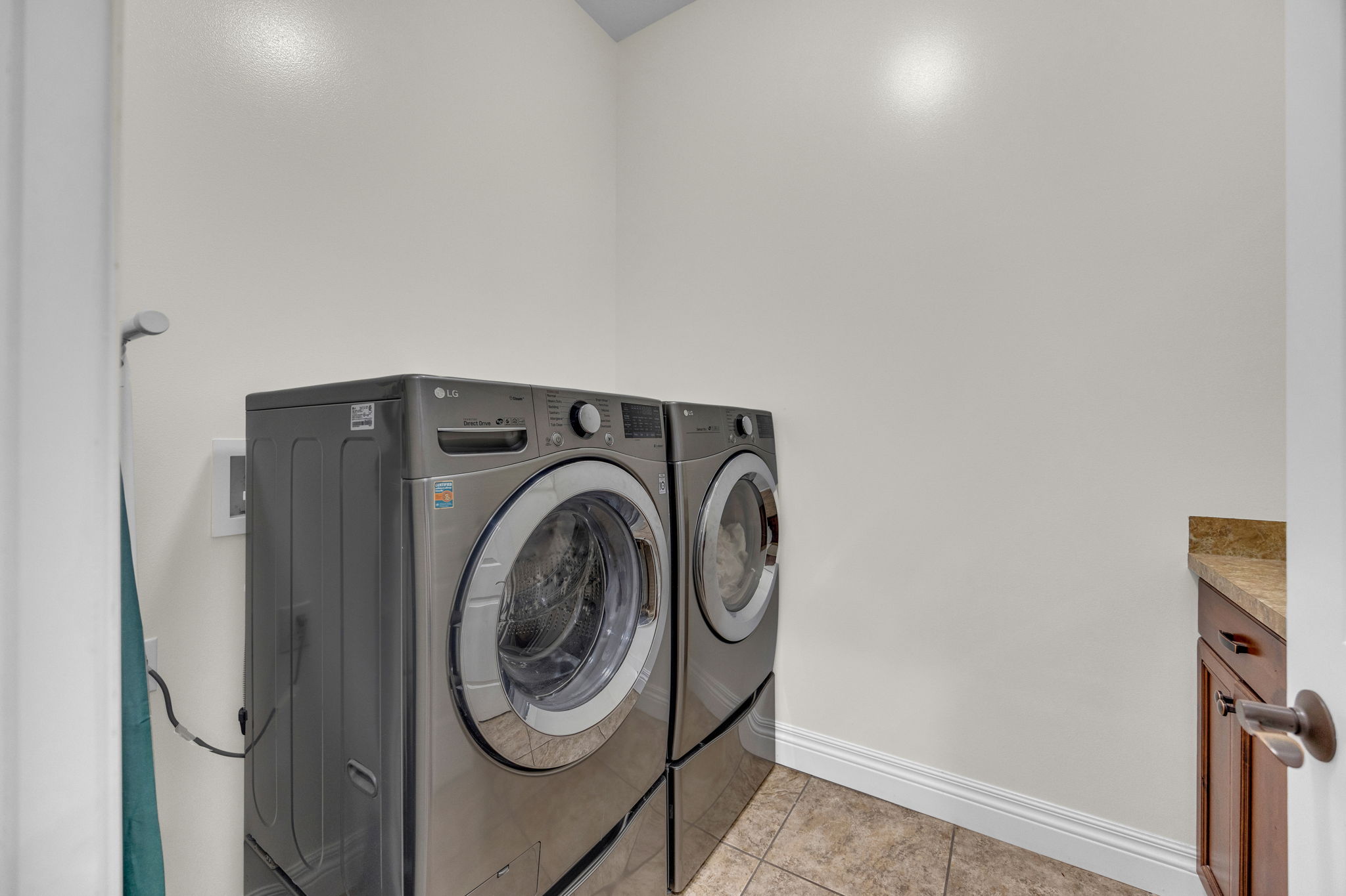 Laundry area featuring separate washer and dryer and light tile patterned floors