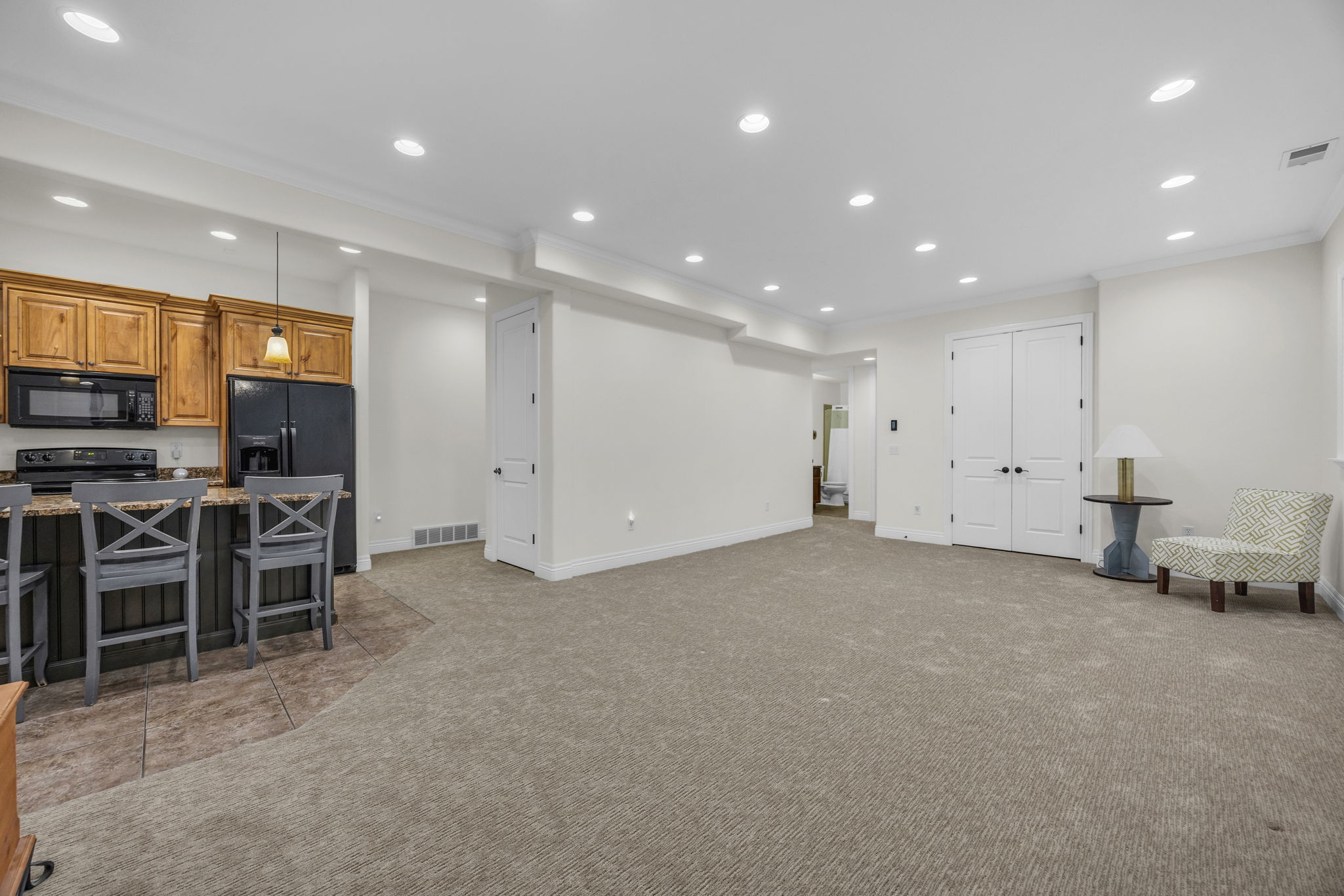 Living area with recessed lighting, crown molding, and light colored carpet
