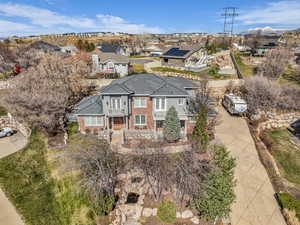 View of front of house featuring brick siding, a balcony, a residential view, and driveway