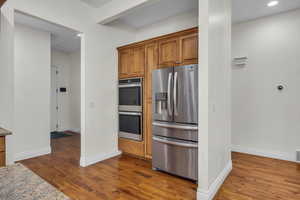 Kitchen featuring stainless steel appliances, wood finish cabinets, dark wood-type flooring, and recessed lighting