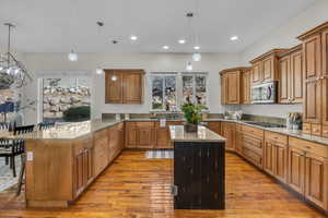 Kitchen with a peninsula, wood finish cabinets, and light stone countertops