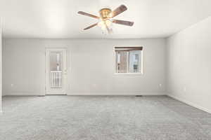 Unfurnished room featuring ceiling fan and carpet