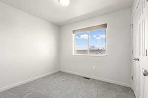 Unfurnished bedroom featuring a closet and light colored carpet