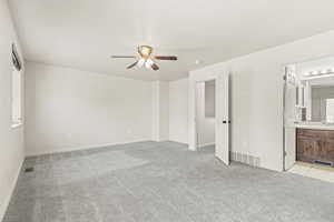 Unfurnished bedroom featuring light colored carpet, a ceiling fan, and ensuite bathroom