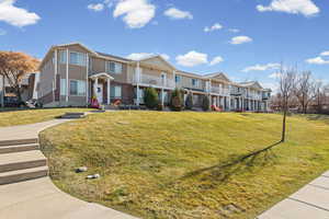 Traditional-style home with brick siding, a residential view, and a front yard