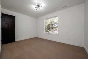 Empty room featuring dark carpet and baseboards