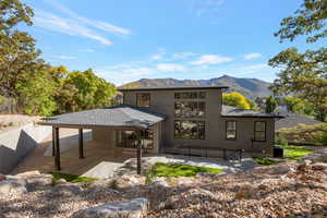 Back of house with a patio area, a mountain view, stucco siding, and a shingled roof