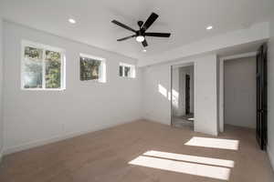 Unfurnished bedroom with light colored carpet, a ceiling fan, and recessed lighting
