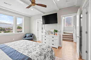 Bedroom with light wood-type flooring, a ceiling fan, recessed lighting, and beam ceiling