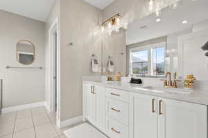 Full bath featuring double vanity, light tile patterned flooring, and a mountain view