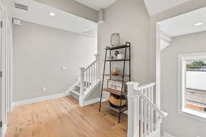 Stairs featuring recessed lighting and hardwood / wood-style flooring