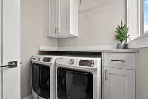 Laundry area featuring cabinet space and separate washer and dryer