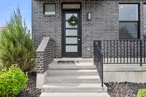 View of exterior entry featuring brick siding