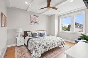 Bedroom featuring light wood-style floors, ceiling fan, recessed lighting, and beamed ceiling