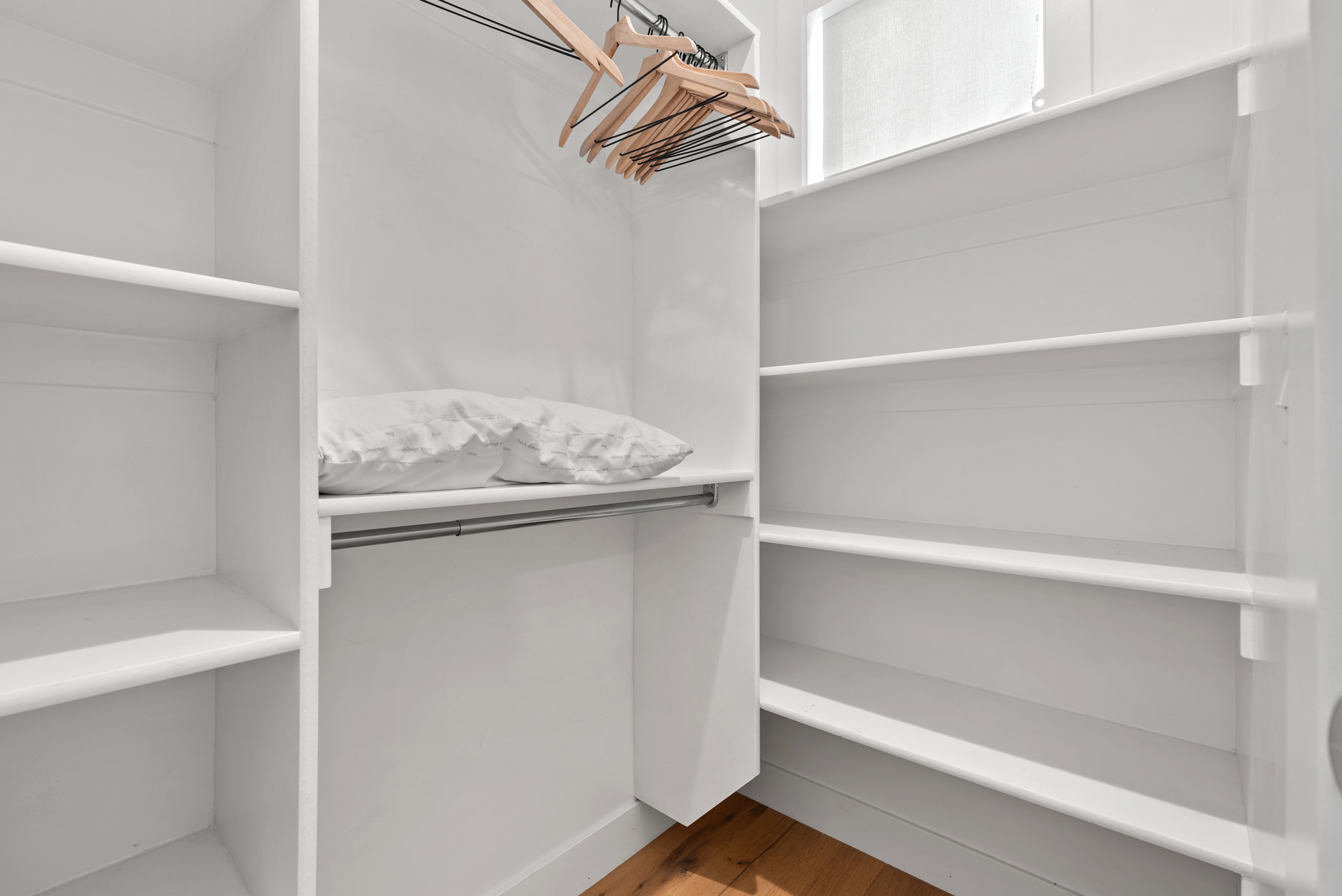 Walk in closet with light wood-style floors