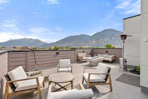 View of patio featuring an outdoor living space with a fire pit and a mountain view