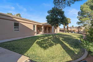 View of grassy yard featuring a patio