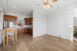Kitchen featuring stainless steel appliances, ceiling fan, wood finish floors, recessed lighting, and wood finish cabinets