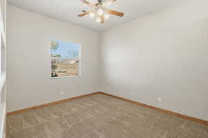 Unfurnished room featuring light colored carpet and ceiling fan