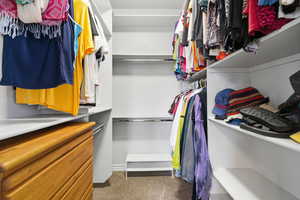 Walk in closet featuring dark colored carpet