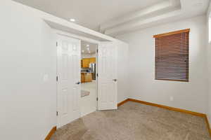 Unfurnished bedroom with light carpet, recessed lighting, and stainless steel fridge