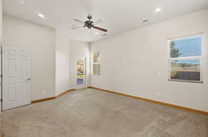 Empty room featuring light colored carpet, a ceiling fan, and recessed lighting