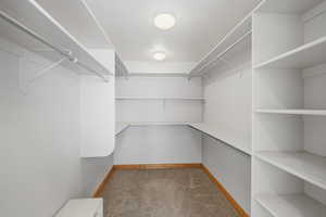 Walk in closet featuring dark carpet