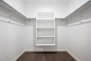 Walk in closet featuring dark carpet