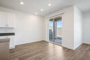 Unfurnished dining area with light wood-type flooring and recessed lighting