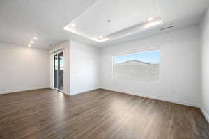 Empty room with recessed lighting and dark wood-style flooring