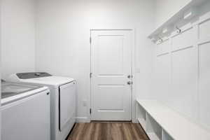 Laundry room with dark wood-style floors and independent washer and dryer