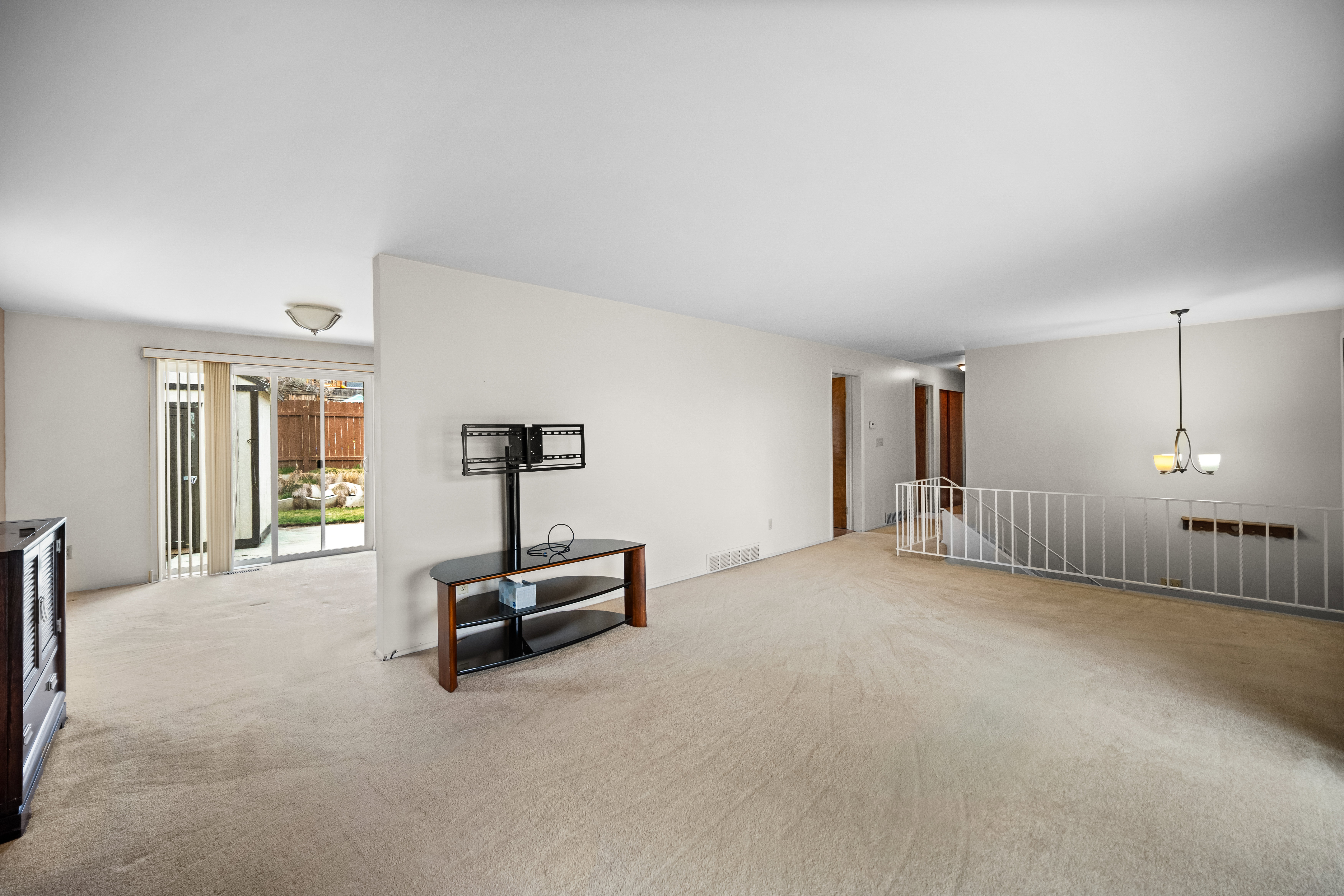Spare room featuring a chandelier and carpet floors