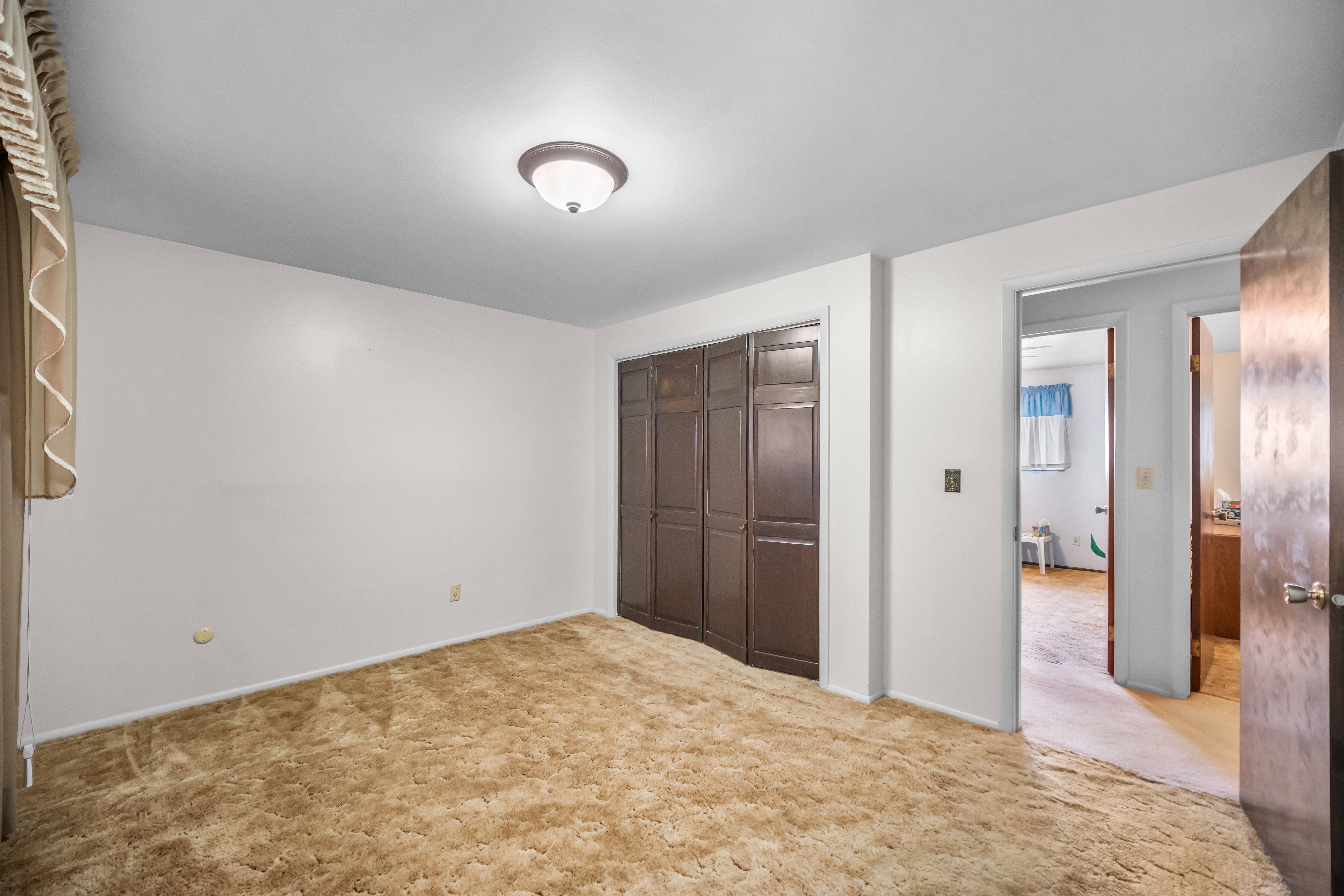 Unfurnished bedroom featuring light colored carpet and a closet