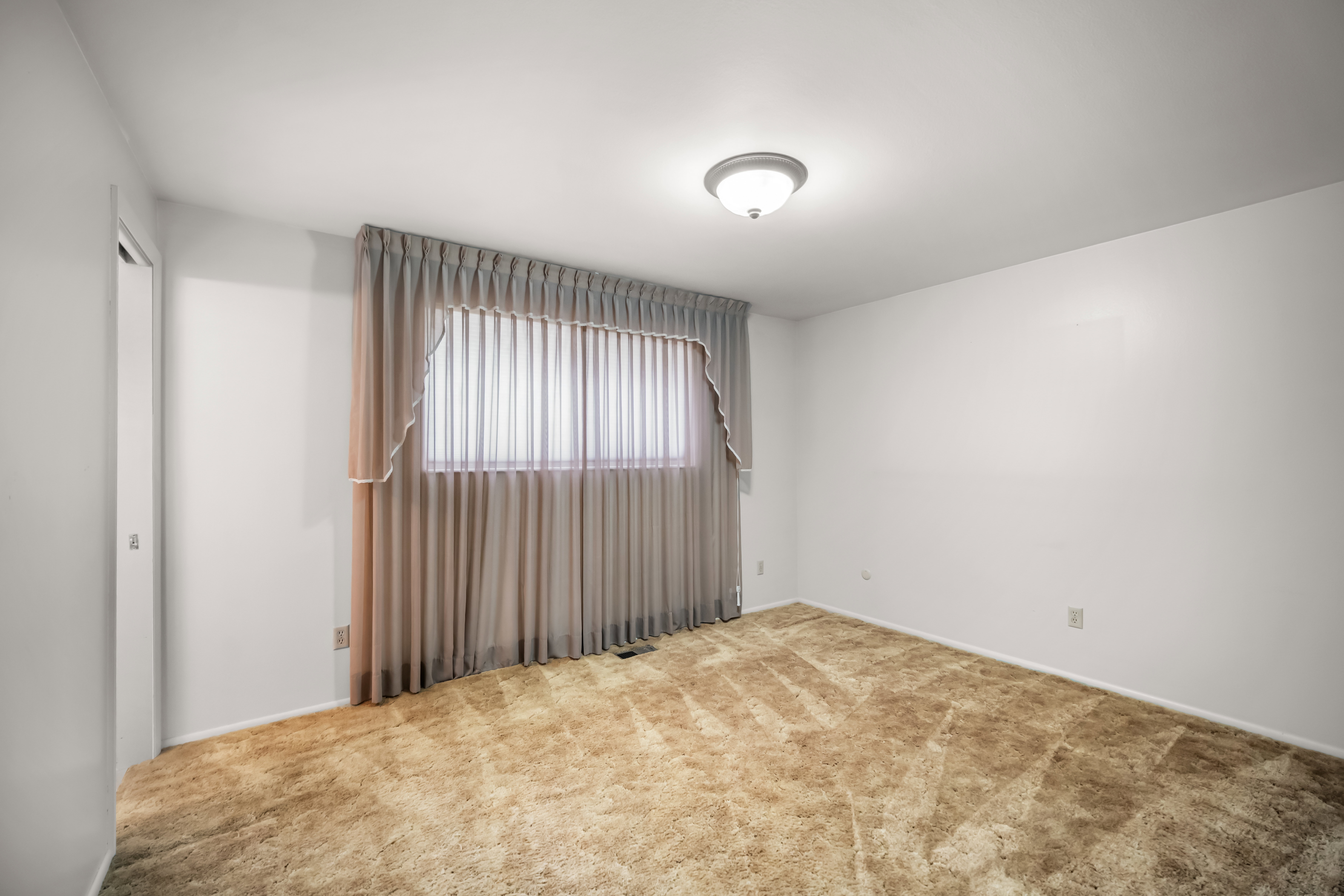 Carpeted empty room with baseboards