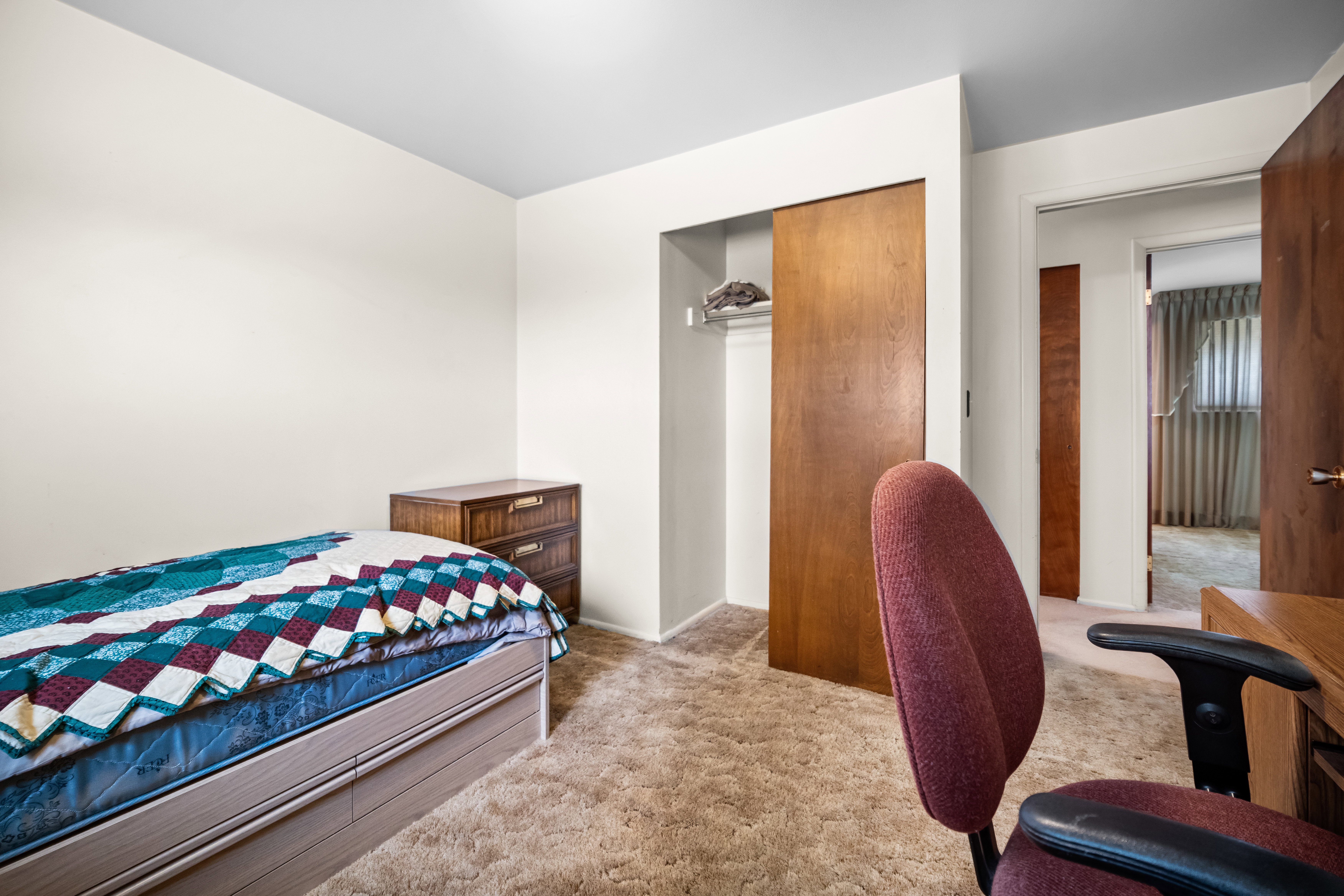 Bedroom featuring light colored carpet and a closet