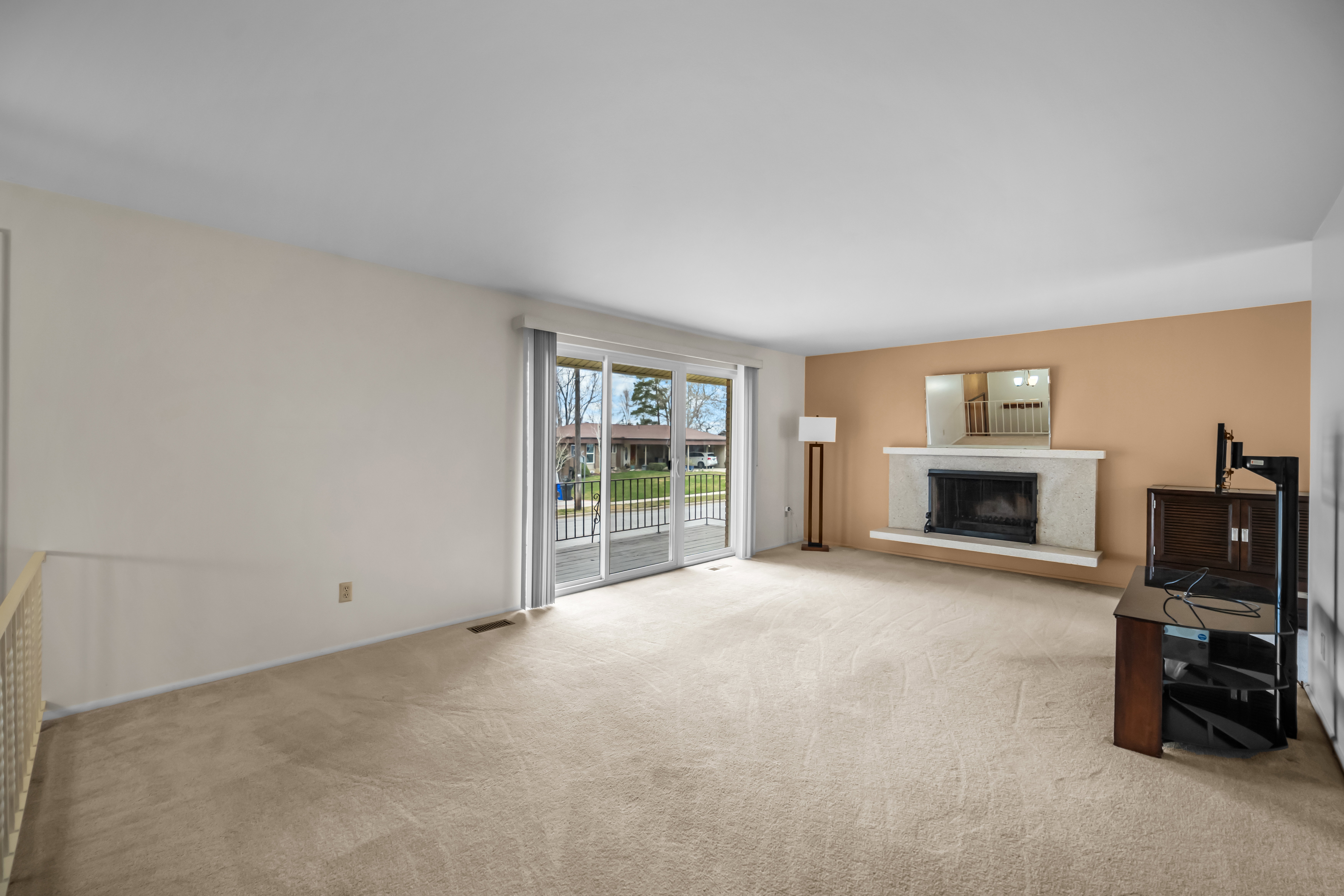 Unfurnished living room with light carpet and a premium fireplace