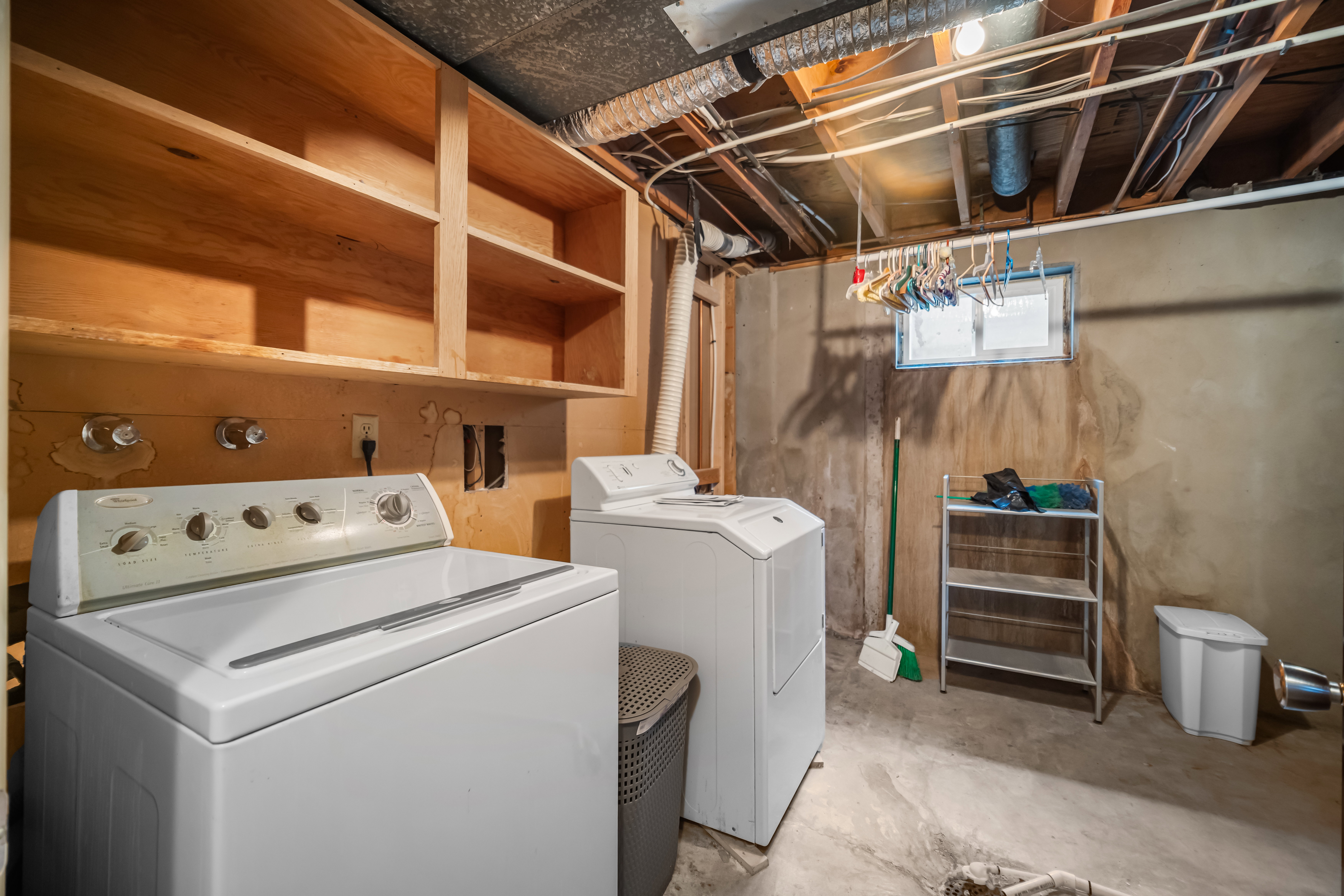 Laundry area with washer and dryer and unfinished concrete floors